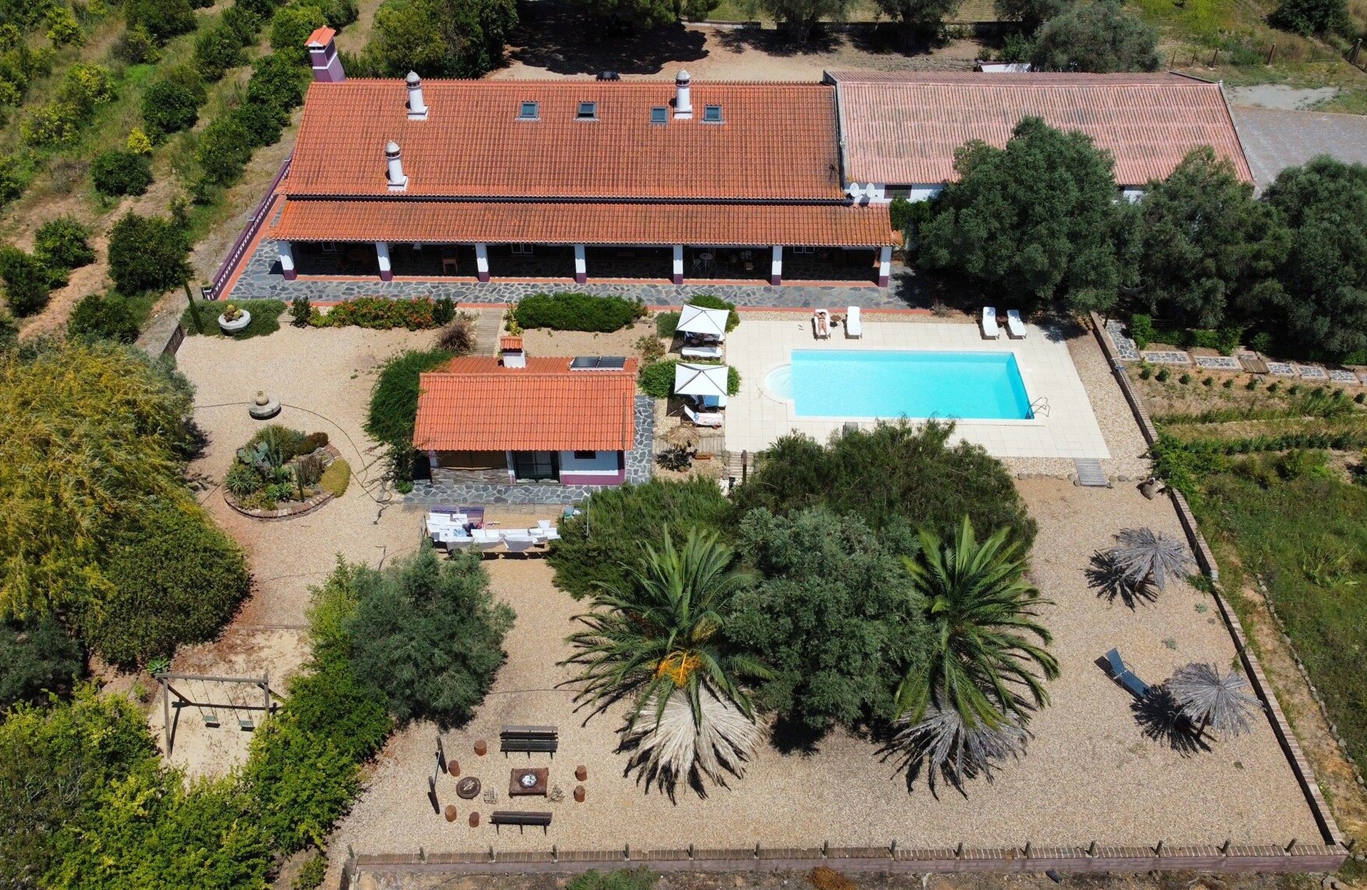 Vista aérea do Monte da Floresta, casa rural alentejana rodeada de jardim e com piscina, em Ferreira do Alentejo.